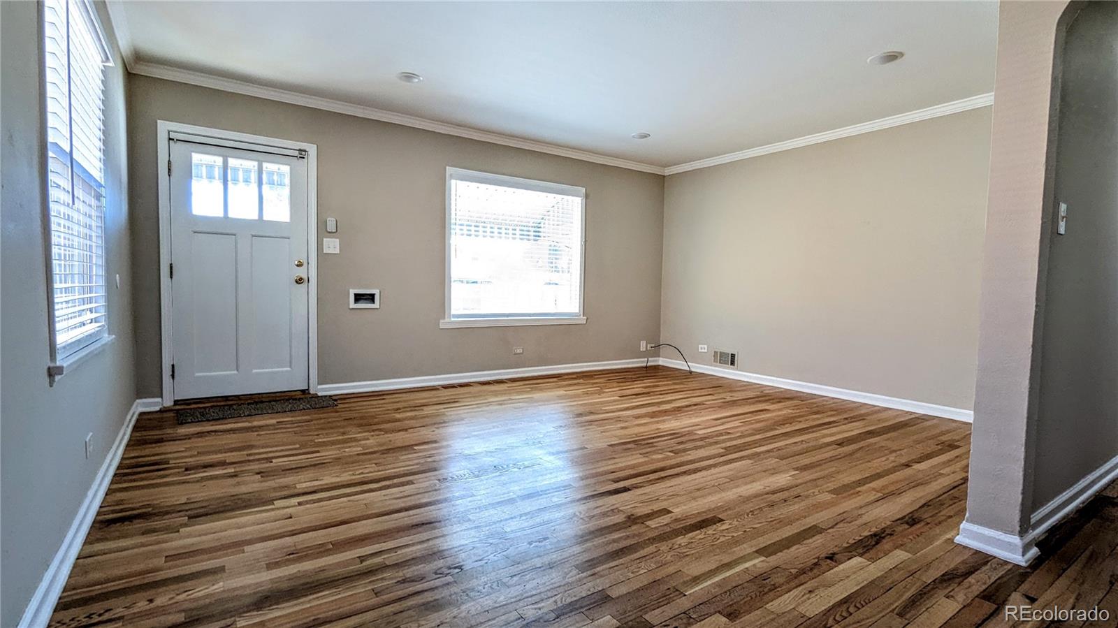 3349 Adams Street Denver, CO 80205 - Photo 5 of 31 an empty room with wooden floor and windows