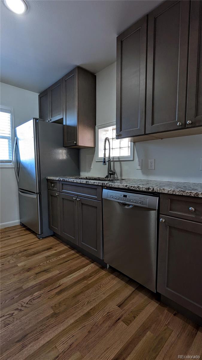 3349 Adams Street Denver, CO 80205 - Photo 8 of 31 a kitchen with granite countertop stainless steel appliances a sink and cabinets