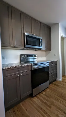 a kitchen with stainless steel appliances granite countertop a stove microwave and sink
