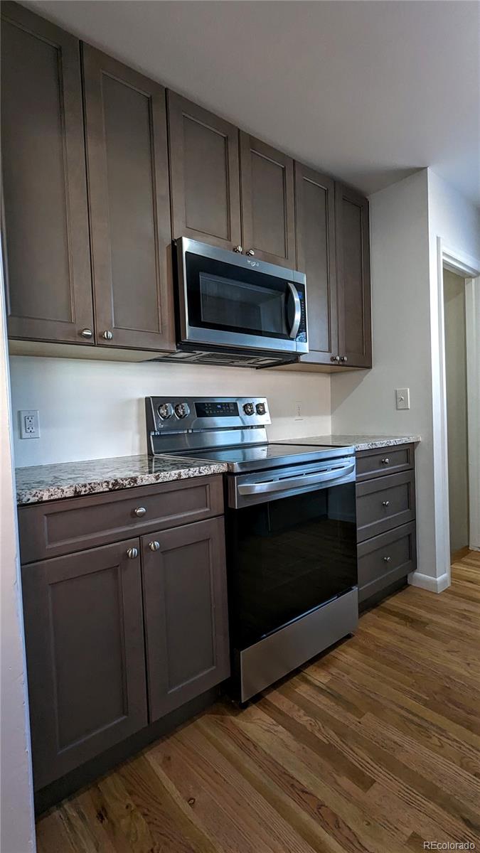 3349 Adams Street Denver, CO 80205 - Photo 9 of 31 a kitchen with stainless steel appliances granite countertop a stove microwave and sink