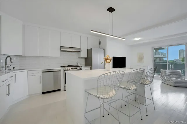 a kitchen with stainless steel appliances kitchen island granite countertop a table chairs microwave and sink