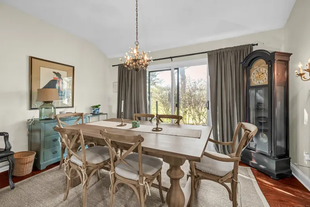a dining room with furniture a chandelier and window