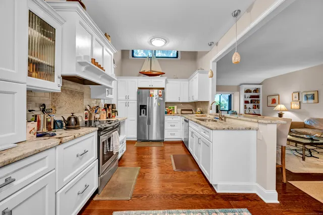 a large kitchen with stainless steel appliances lots of counter space and wooden floor