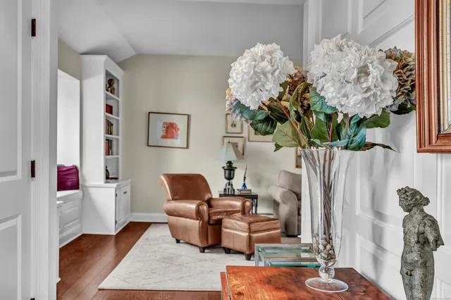 a living room with furniture flowerpot and wooden floor