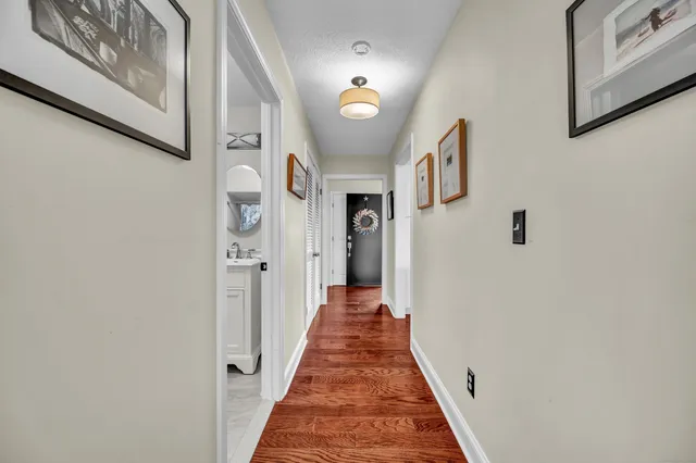 a view of a hallway with wooden floor and staircase