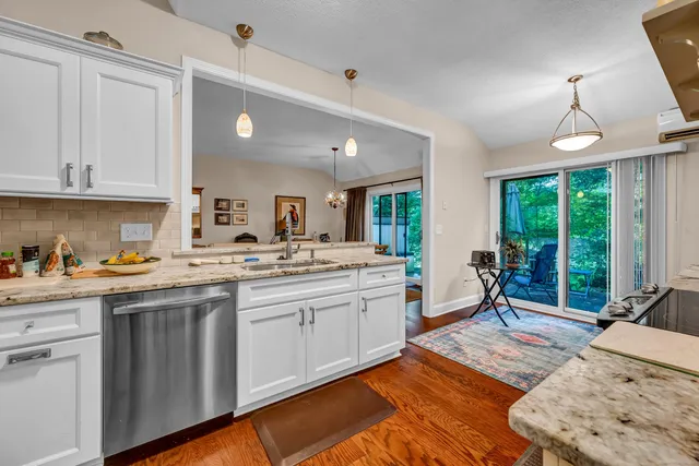 a large kitchen with kitchen island granite countertop a large window a sink and stainless steel appliances