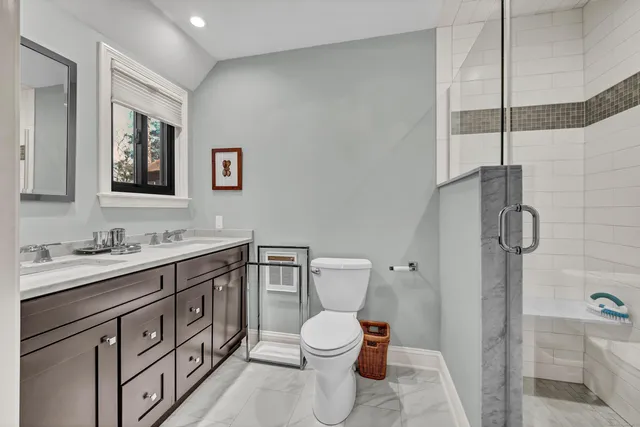 a bathroom with a toilet sink a mirror and vanity