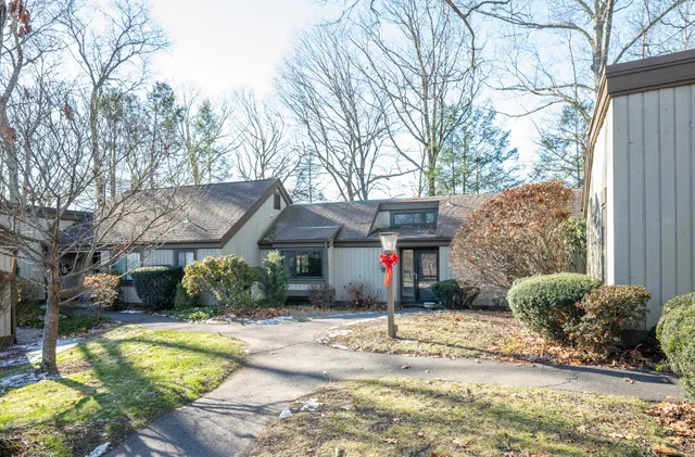 a front view of a house with a yard and potted plants