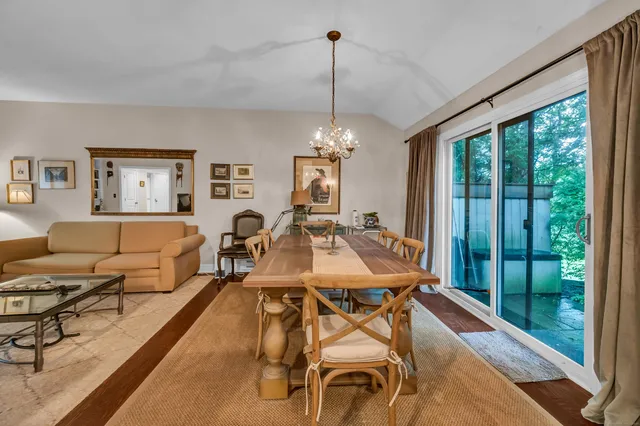 a living room with furniture a chandelier and a large window