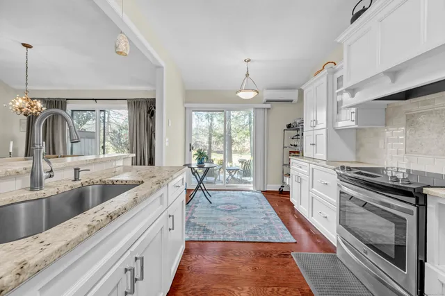 a large kitchen with granite countertop a stove and a sink