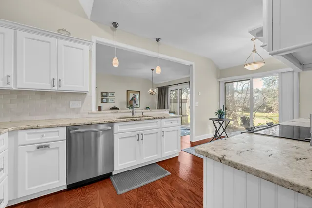 a kitchen with granite countertop white cabinets and white appliances