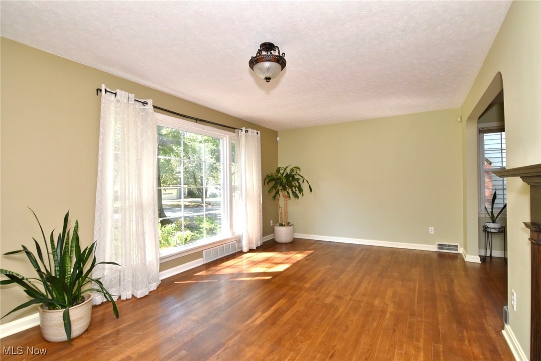 3679 Fenley Road Cleveland Heights, OH 44121 - Photo 5 of 45 Empty room featuring dark wood-type flooring and a textured ceiling
