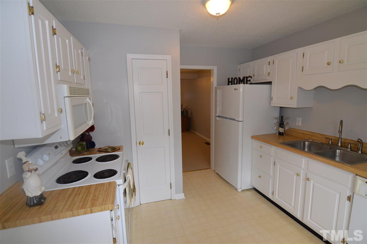 6587 English Oaks Drive Raleigh, NC 27615 - Photo 3 of 21 White cabinets, refrigerator, microwave, dishwasher