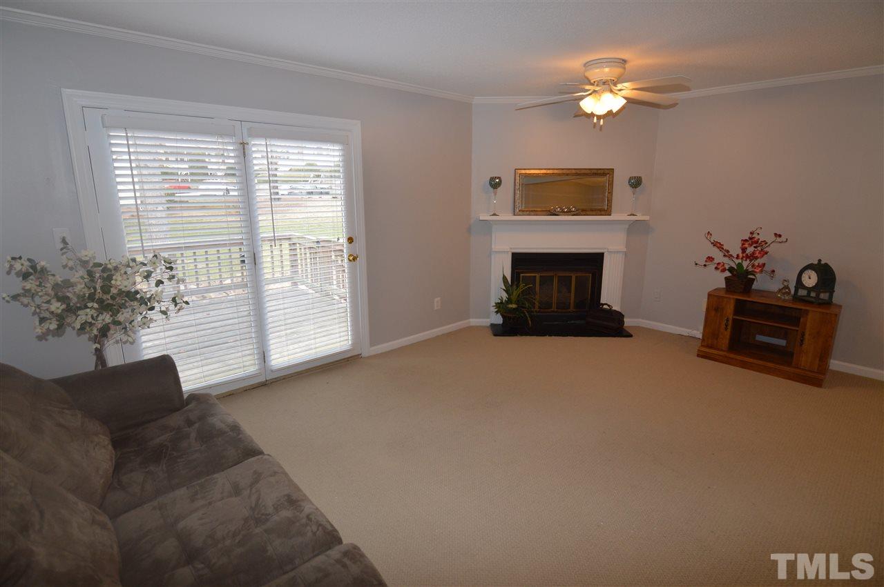 6587 English Oaks Drive Raleigh, NC 27615 - Photo 7 of 21 Accented with gas log fireplace and French doors leading to deck.