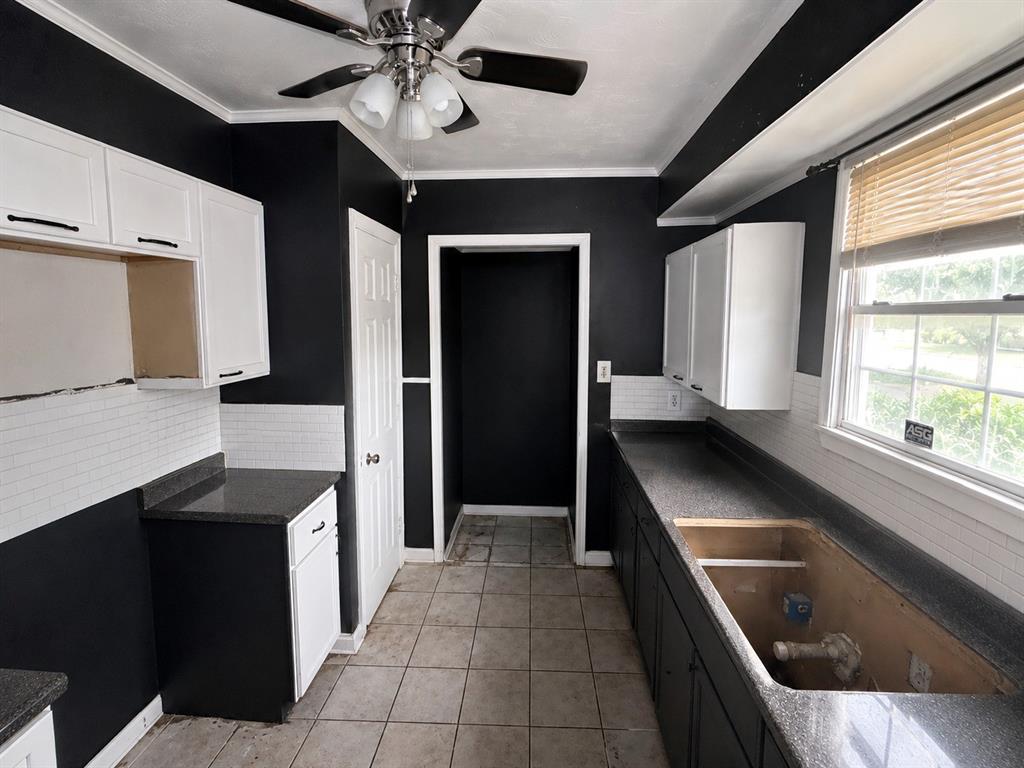 1010 Winters Street Dallas, TX 75216 - Photo 9 of 20 Kitchen featuring a ceiling fan, white upper cabinetry, dark lower cabinetry, dark countertops, and a subway tile backsplash