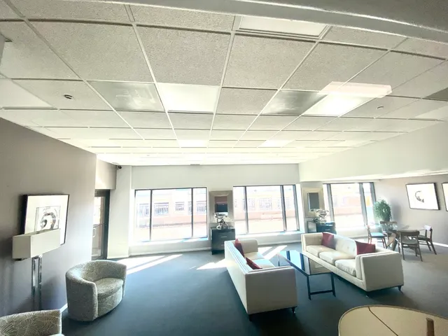 a view of a room with furniture large windows and wooden floor