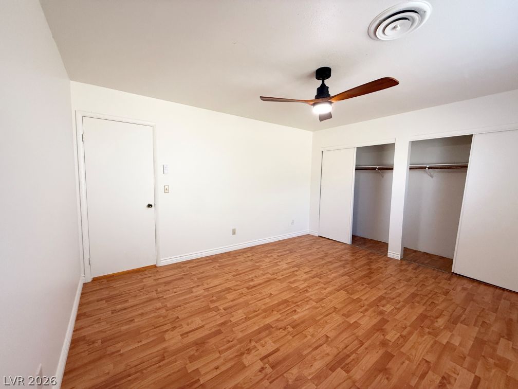 616 Greenway Road Henderson, NV 89002 - Photo 18 of 32 A comfortable bedroom with rich wood flooring and ample closet space awaits its new occupant.