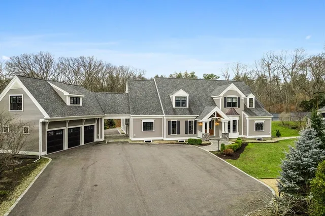 a front view of a house with a yard and lake view