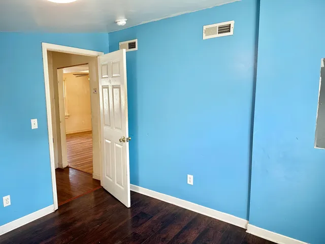 a view of empty room with wooden floor