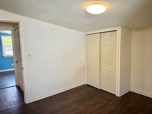 an empty room with wooden floor and closet