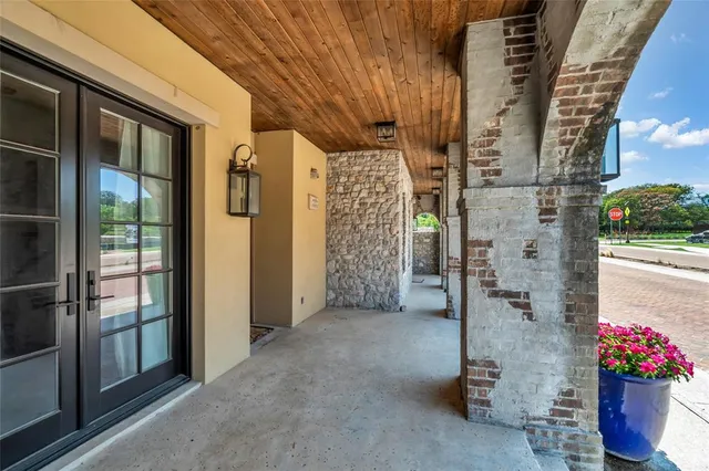 a view of a brick house with a potted plant and a street view