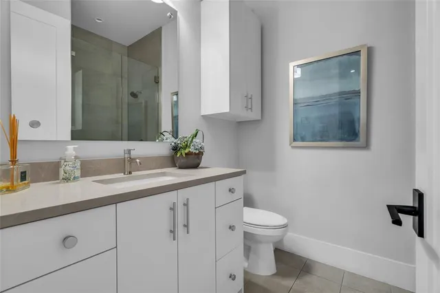 a bathroom with a granite countertop sink a toilet and a mirror