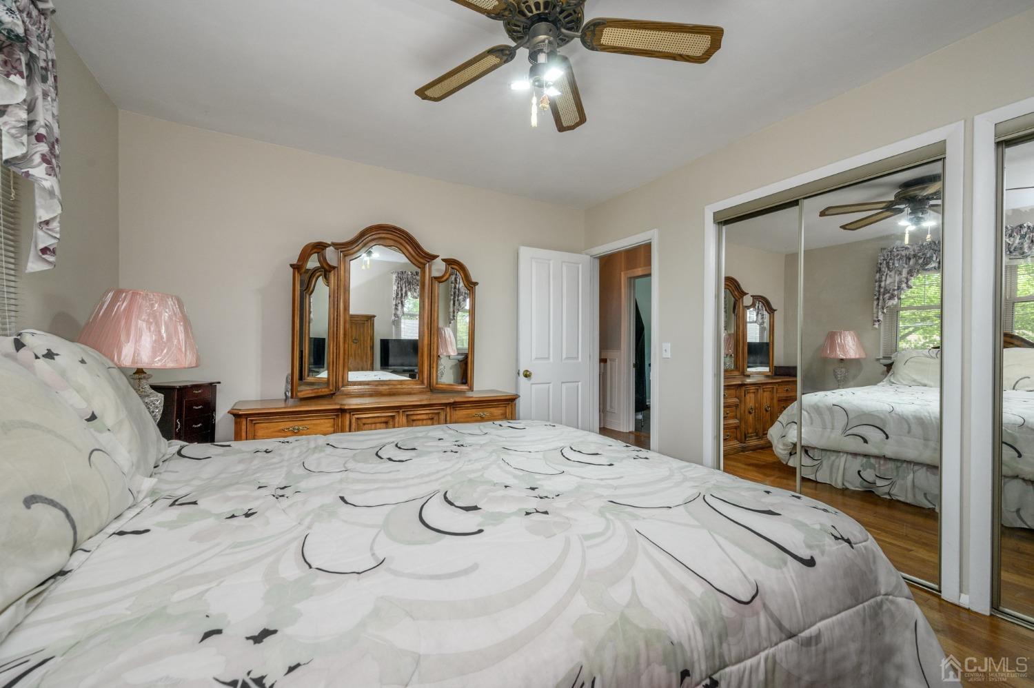 54 Manito Road Manasquan, NJ 08736 - Photo 20 of 47 a bedroom with a large bed and a chandelier