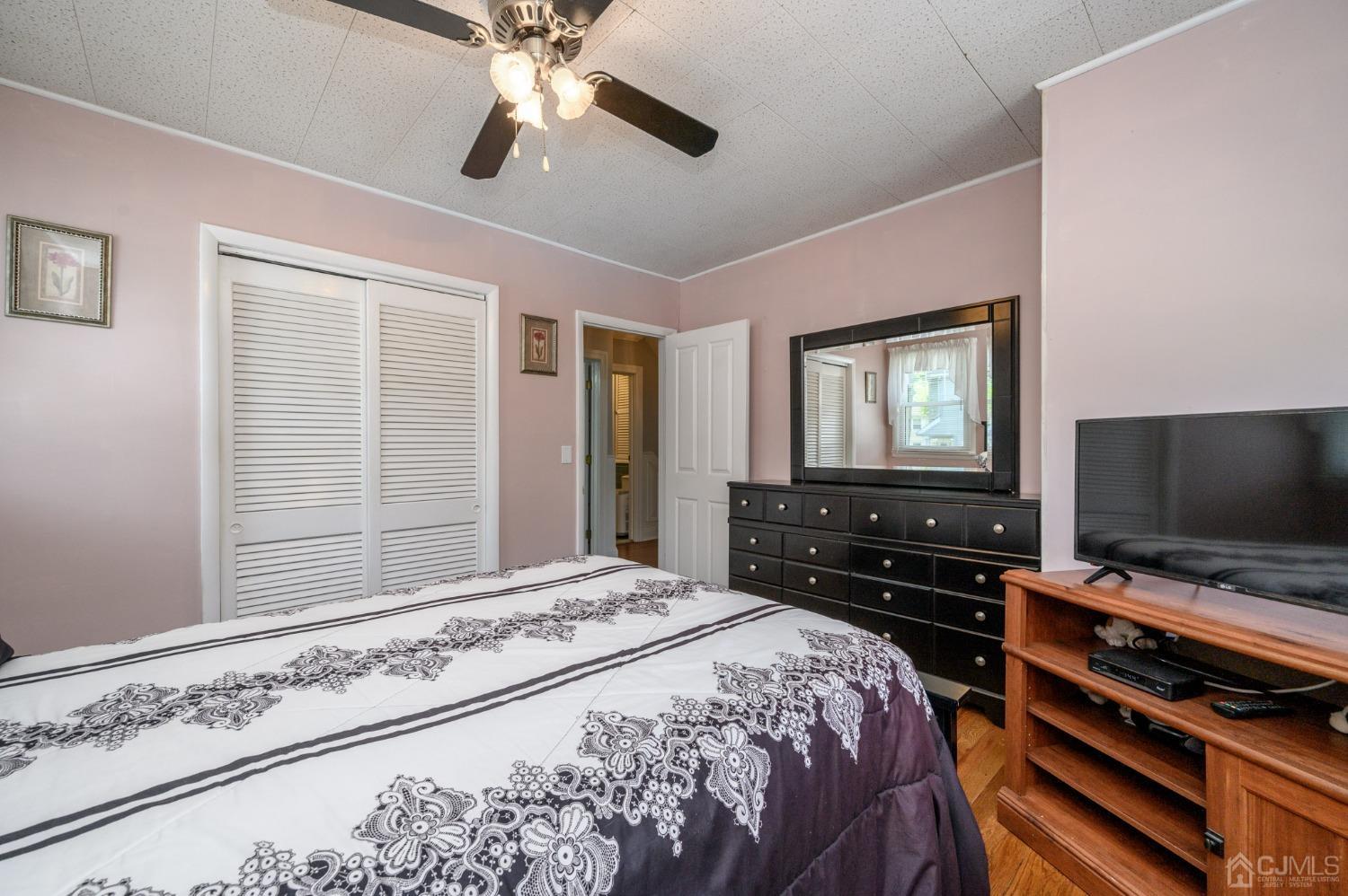 54 Manito Road Manasquan, NJ 08736 - Photo 22 of 47 a bedroom with a bed and a flat screen tv