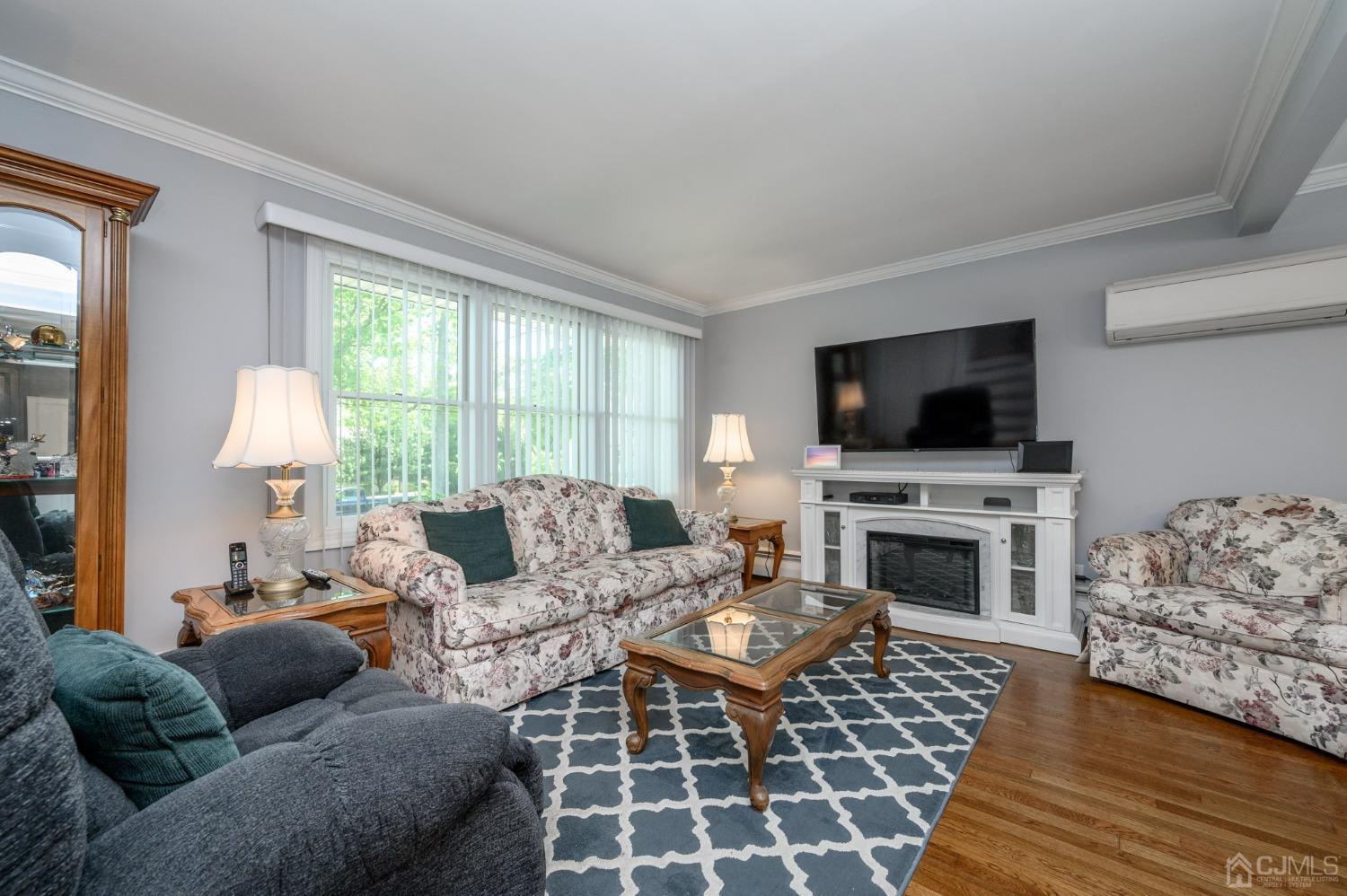54 Manito Road Manasquan, NJ 08736 - Photo 4 of 47 a living room with furniture a flat screen tv and a fireplace