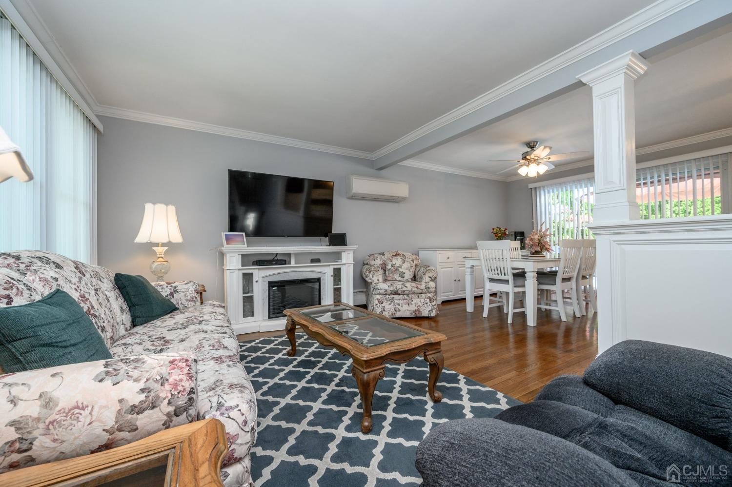 54 Manito Road Manasquan, NJ 08736 - Photo 5 of 47 a living room with furniture a flat screen tv and a fireplace