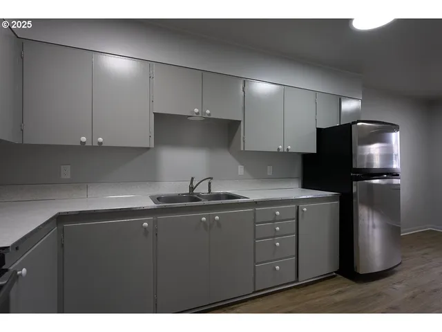 a kitchen with a sink a refrigerator and cabinets
