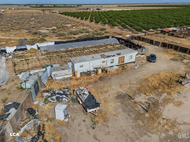 a view of a big yard with a table and chairs under an umbrella
