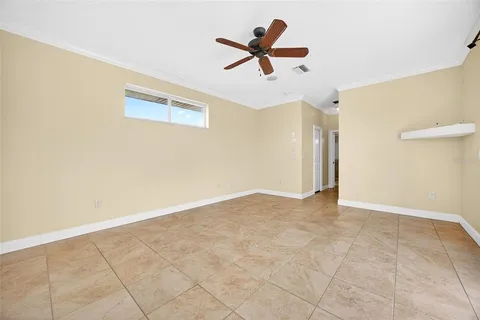an empty room with a ceiling fan and a window