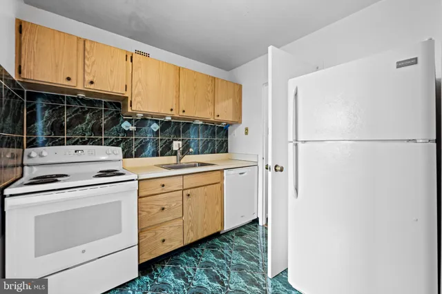 a kitchen with stainless steel appliances white cabinets and a refrigerator