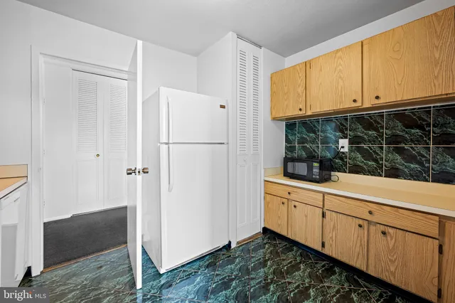 a kitchen with white cabinets and white appliances