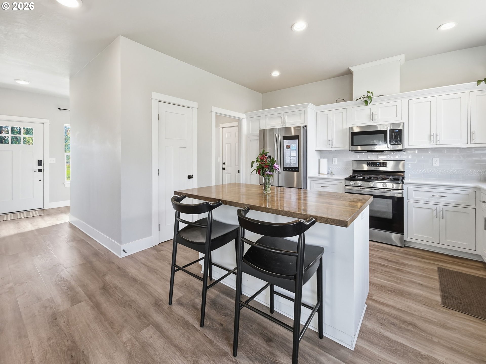 1310 Elm Street Junction City, OR 97448 - Photo 9 of 39 a kitchen with stainless steel appliances granite countertop a stove top oven a sink dishwasher and white cabinets with wooden floor
