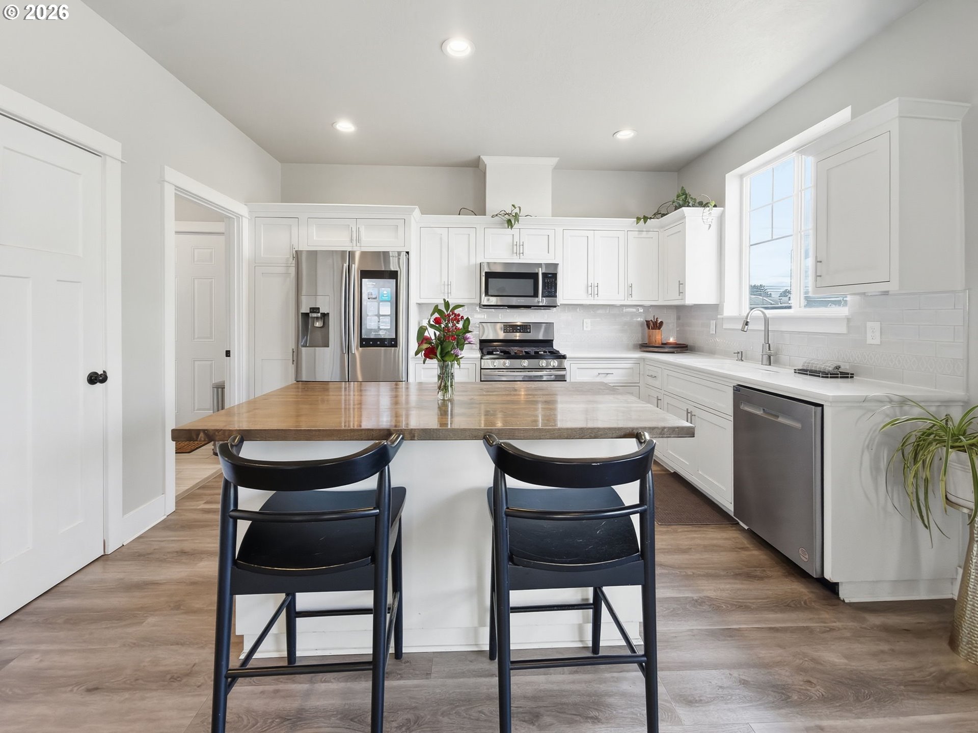 1310 Elm Street Junction City, OR 97448 - Photo 10 of 39 a kitchen with refrigerator a sink and chairs