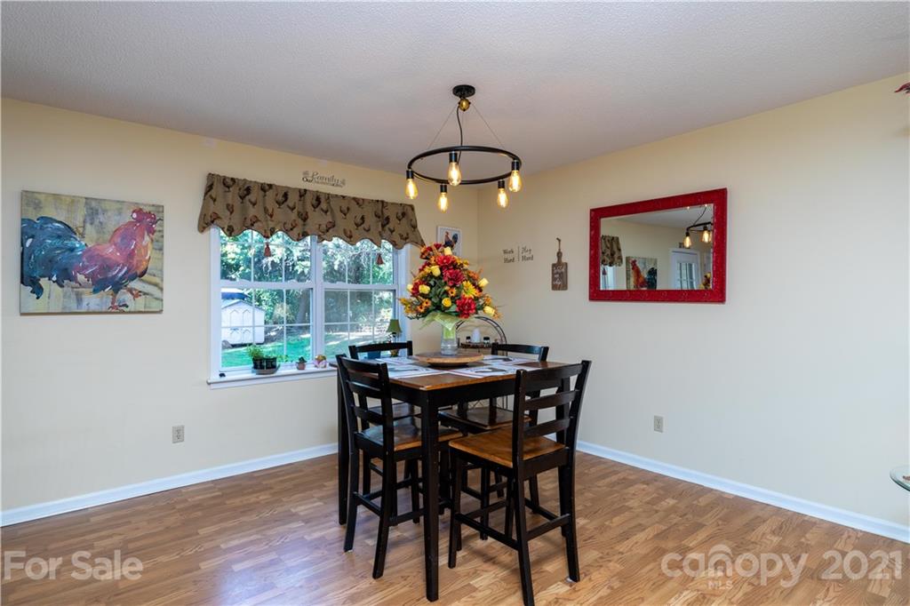 762 State Rd S-46-1086 Clover, SC 29710 - Photo 5 of 34 a dining room with wooden floor a chandelier a wooden table and chairs