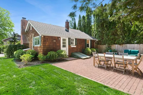 a view of backyard of house with a patio