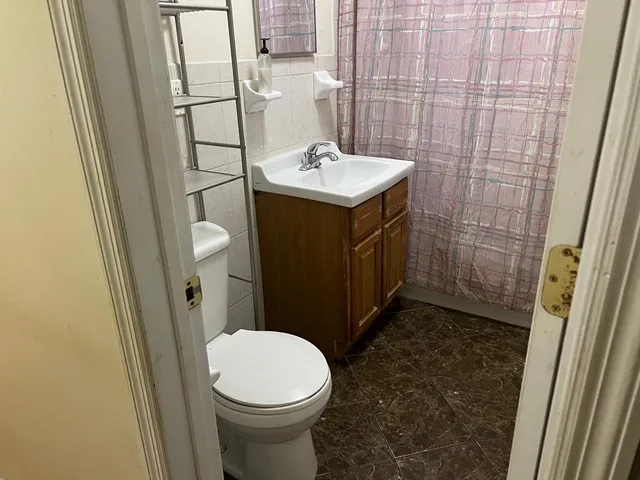 a bathroom with a sink a toilet a mirror and shower