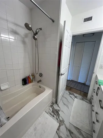 a bathroom with a tub sink and mirror
