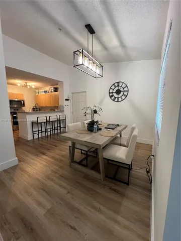 a view of a dining room with furniture wooden floor and chandelier