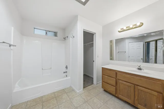 a spacious bathroom with a tub sink shower and mirror