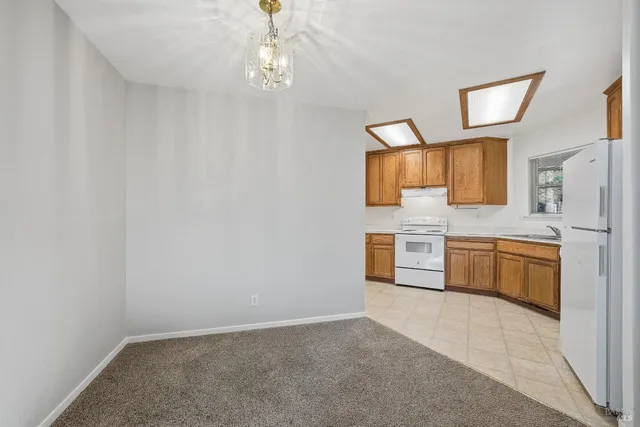 a view of a kitchen with a sink and dishwasher a stove top oven with wooden floor