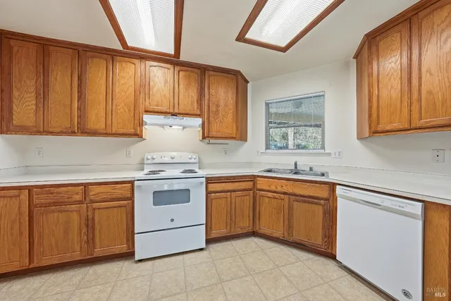 a kitchen with cabinets appliances and a window