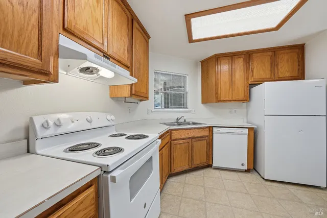 a kitchen with stainless steel appliances granite countertop a stove a refrigerator and a sink