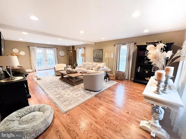 a living room with stainless steel appliances furniture a refrigerator a kitchen view and a couch