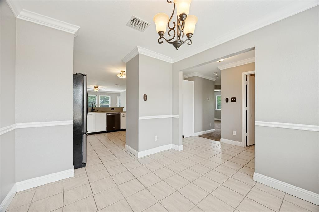 1601 Elm Street Anna, TX 75409 - Photo 4 of 25 an empty room with kitchen view and a chandelier fan