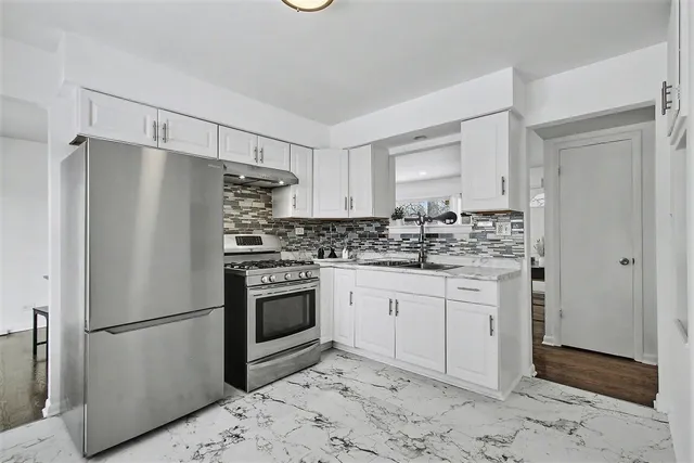 a kitchen with stainless steel appliances granite countertop a refrigerator sink and stove