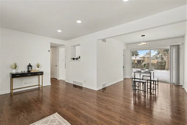 a view of a big room with wooden floor and windows